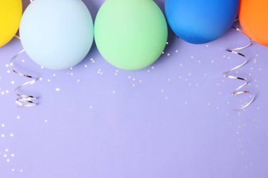 Balonlar, kurdeleler ve konfeti bir renkli arka plan üstüne görüntüleyin. Kutlama