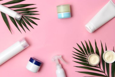 Renkli arka plan görünümlü doğal kozmetik ve yeşil yaprak. Düz çizgi 