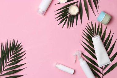 Renkli arka plan görünümlü doğal kozmetik ve yeşil yaprak. Düz çizgi 