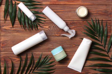 Renkli arka plan görünümlü doğal kozmetik ve yeşil yaprak. Düz çizgi 