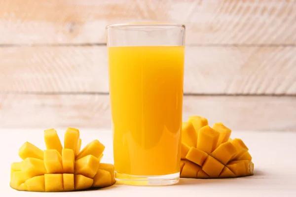 mango juice in a glass and mango fruit.