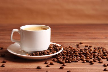 Ahşap arka planda bir fincan aromatik kahve ve kahve çekirdeği. Üst Manzara. Kahve.
