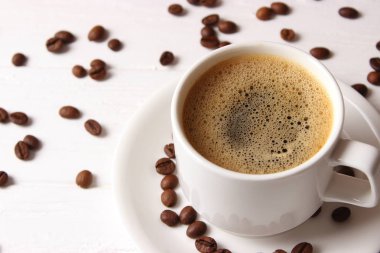 Ahşap arka planda bir fincan aromatik kahve ve kahve çekirdeği. Üst Manzara. Kahve.