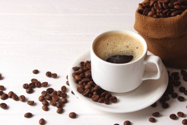 Ahşap arka planda bir fincan aromatik kahve ve kahve çekirdeği. Üst Manzara. Kahve.