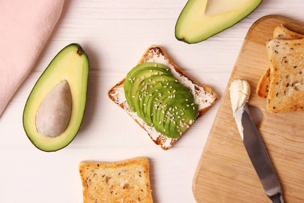 Toasted toast with avocado on a wooden table.