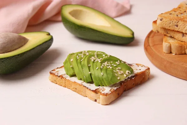 Toasted toast with avocado on a wooden table.