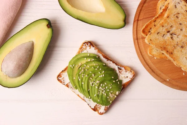 Toasted toast with avocado on a wooden table.