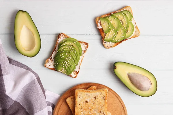 Toasted toast with avocado on a wooden table.