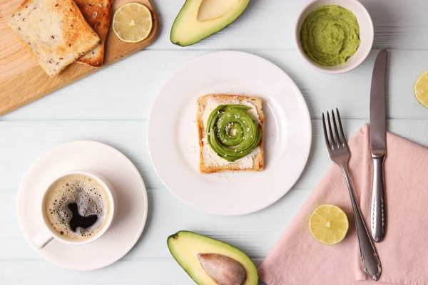 Toasted toast with avocado on a wooden table.