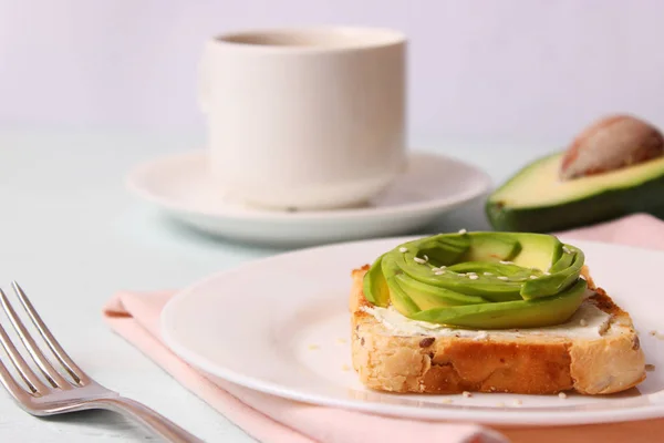 Toasted toast with avocado on a wooden table.