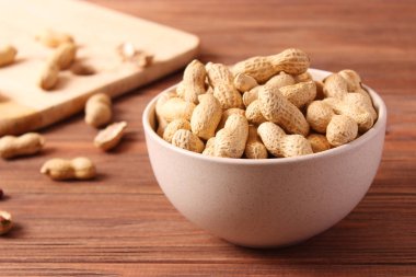 Ahşap bir arka planda kabuklu çiğ fıstık.