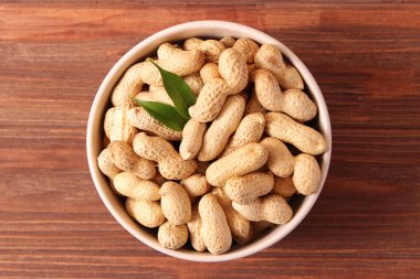 Ahşap bir arka planda kabuklu çiğ fıstık.