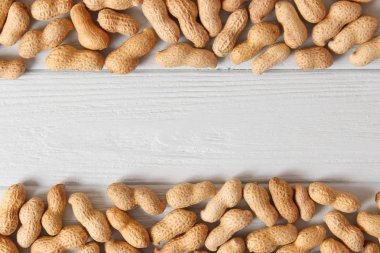 Ahşap bir arka planda kabuklu çiğ fıstık.