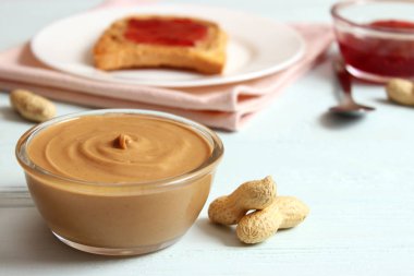 Ahşap arka planda fıstık ezmesi ve fıstık ezmesi.