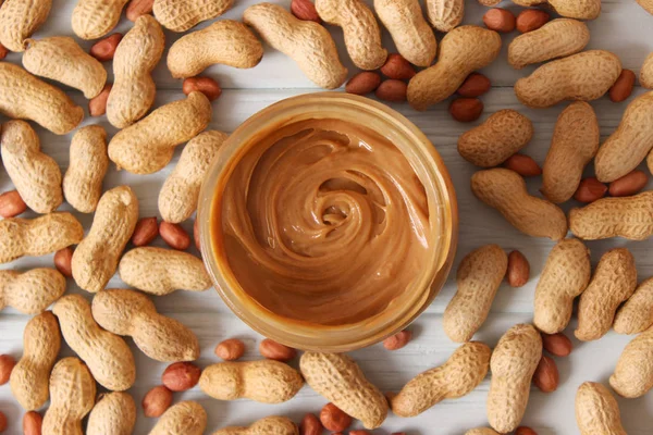 peanut butter and peanut beans on wooden background