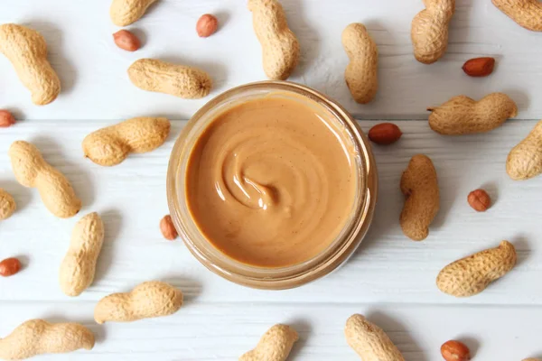 peanut butter and peanut beans on wooden background