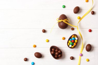 Paskalya kompozisyonu çikolatalı yumurtalar ve ahşap arka planda çikolatalı tavşan, mesaj için yer 