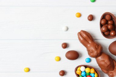 Paskalya kompozisyonu çikolatalı yumurtalar ve ahşap arka planda çikolatalı tavşan, mesaj için yer 