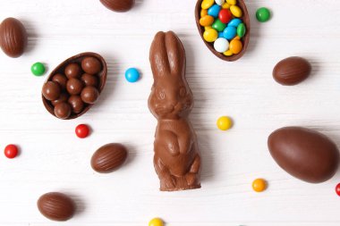 Paskalya kompozisyonu çikolatalı yumurtalar ve ahşap arka planda çikolatalı tavşan, mesaj için yer 