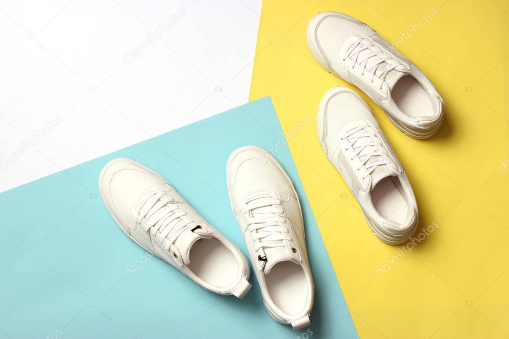 Men's and women's sneakers on a colored background top view. Sport shoes. White running shoes