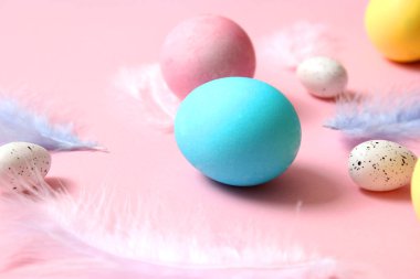 Paskalya bileşimi boyalı yumurta ve renkli bir arka plan tüyler. Paskalya arka plan