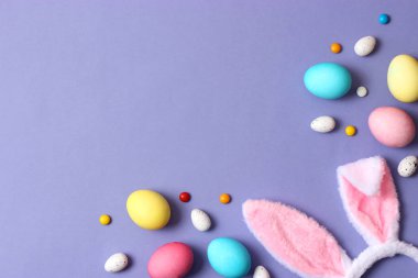 Paskalya bileşimi boyalı yumurta ve renkli bir arka plan tüyler. Paskalya arka plan