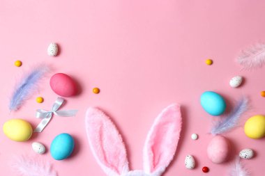 Paskalya bileşimi boyalı yumurta ve renkli bir arka plan tüyler. Paskalya arka plan