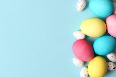 Paskalya bileşimi boyalı yumurta ve renkli bir arka plan tüyler. Paskalya arka plan