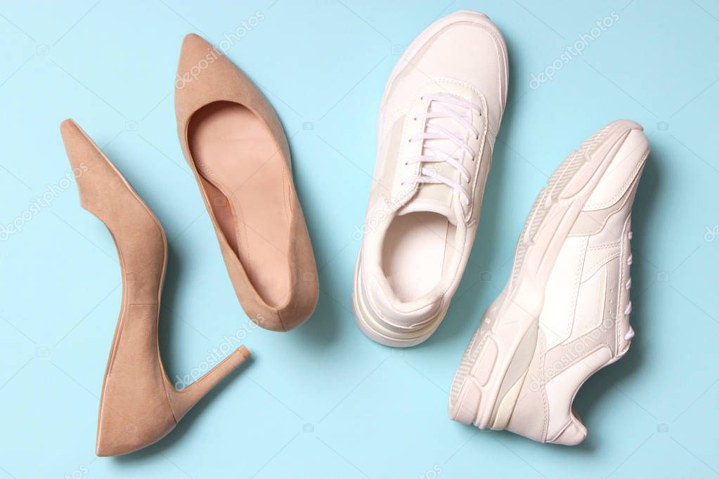 white sneakers and high heel shoes on a colored background top view. Women's shoes. Classic and sport shoes.