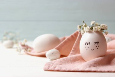 kompozisyon bir yere metin eklemek Paskalya için. çiçek çelenk ve boyalı yüzü sevimli yumurta.