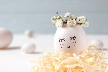 kompozisyon bir yere metin eklemek Paskalya için. çiçek çelenk ve boyalı yüzü sevimli yumurta.