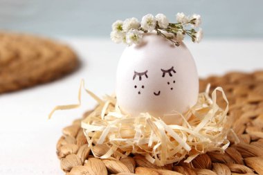 kompozisyon bir yere metin eklemek Paskalya için. çiçek çelenk ve boyalı yüzü sevimli yumurta.