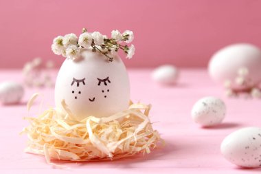 kompozisyon bir yere metin eklemek Paskalya için. çiçek çelenk ve boyalı yüzü sevimli yumurta.