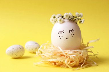 kompozisyon bir yere metin eklemek Paskalya için. çiçek çelenk ve boyalı yüzü sevimli yumurta.