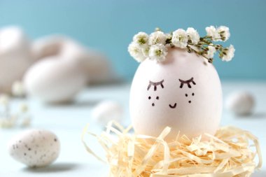 kompozisyon bir yere metin eklemek Paskalya için. çiçek çelenk ve boyalı yüzü sevimli yumurta.