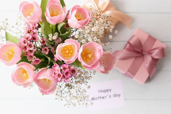 Красивая композиция ко Дню матери на деревянном фоне сверху. Цветы, открытки, подарок
.