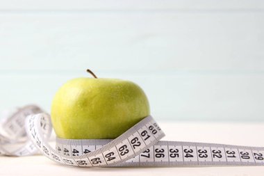 Elma ve mezura renkli arka plan görünümünde.