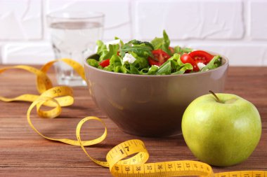 Hafif bir arka planda bant ve marul. Zayıflama, diyet, sağlıklı yiyecekler..