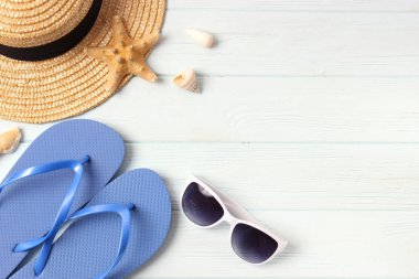 renkli arkaplan görünümünde seyahat aksesuarları ve tropikal yapraklar.