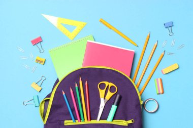 Okul çantası ve okul kırtasiyesi renkli bir arka plan görünümünde. Okula dönüş kavramı.