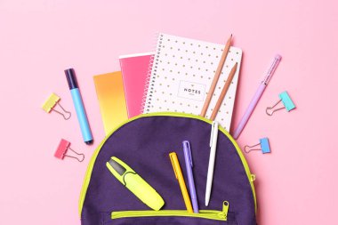 Okul çantası ve okul kırtasiyesi renkli bir arka plan görünümünde. Okula dönüş kavramı.