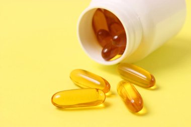 Renkli arka planda Omega-3 kapsülleri. Balık yağı, sağlıklı besinler.