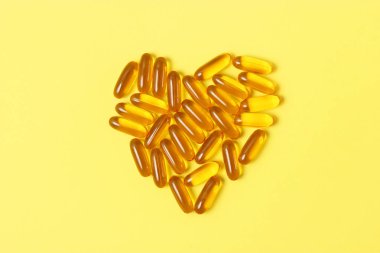 Renkli arka planda Omega-3 kapsülleri. Balık yağı, sağlıklı besinler.