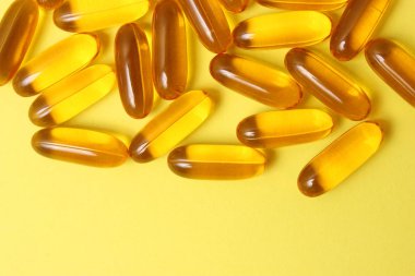 Renkli arka planda Omega-3 kapsülleri. Balık yağı, sağlıklı besinler.