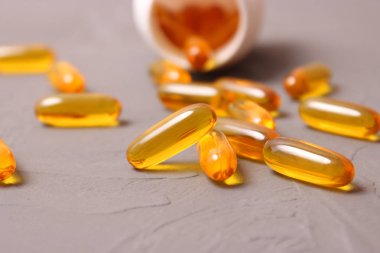 Renkli arka planda Omega-3 kapsülleri. Balık yağı, sağlıklı besinler.