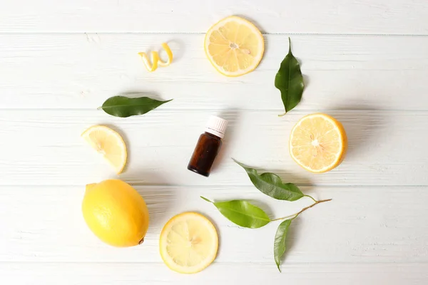 背景にレモンとレモンの精油のボトル — ストック写真
