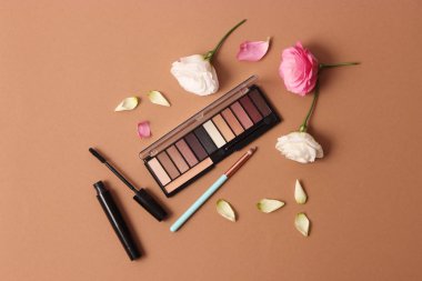 Renkli bir arkaplan görünümünde kozmetik ve çiçekler.