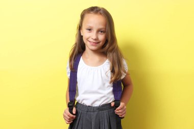 Siyahi bir geçmişi olan, okul çantalı, gülümseyen tatlı bir kız öğrenci. Okul konseptine dönelim.