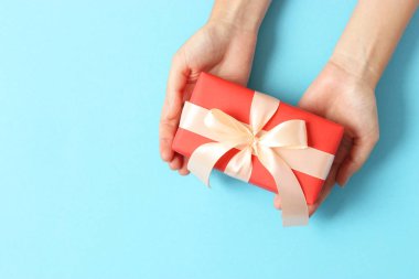 Renkli arka plan görünümlü kadın ellerinde hediye..