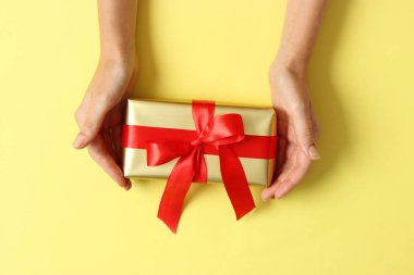 Renkli arka plan görünümlü kadın ellerinde hediye..